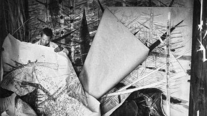Wifredo Lam ante una de sus obras de la serie Brousses en su taller de Albissola, 1963.