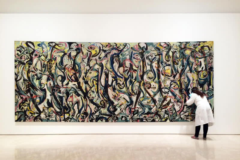Una restauradora del Museo Picasso Málaga examina 'Mural' de Jackson Pollock a su llegada a la pinacoteca malagueña en donde se expone hasta el mes de septiembre © Museo Picasso Málaga.