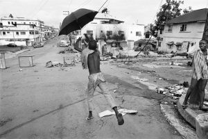 Gervasio Sánchez. Un niño juega con un paraguas en la avenida principal destruida por los combates. Monrovia (Liberia). Mayo de 1996.