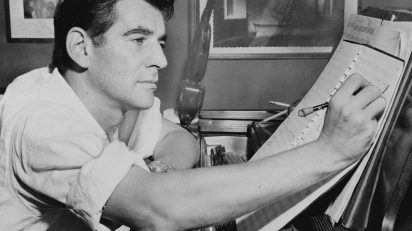 1955. Leonard Bernstein sentado al piano, anotando una partitura. Foto: Al Ravenna.