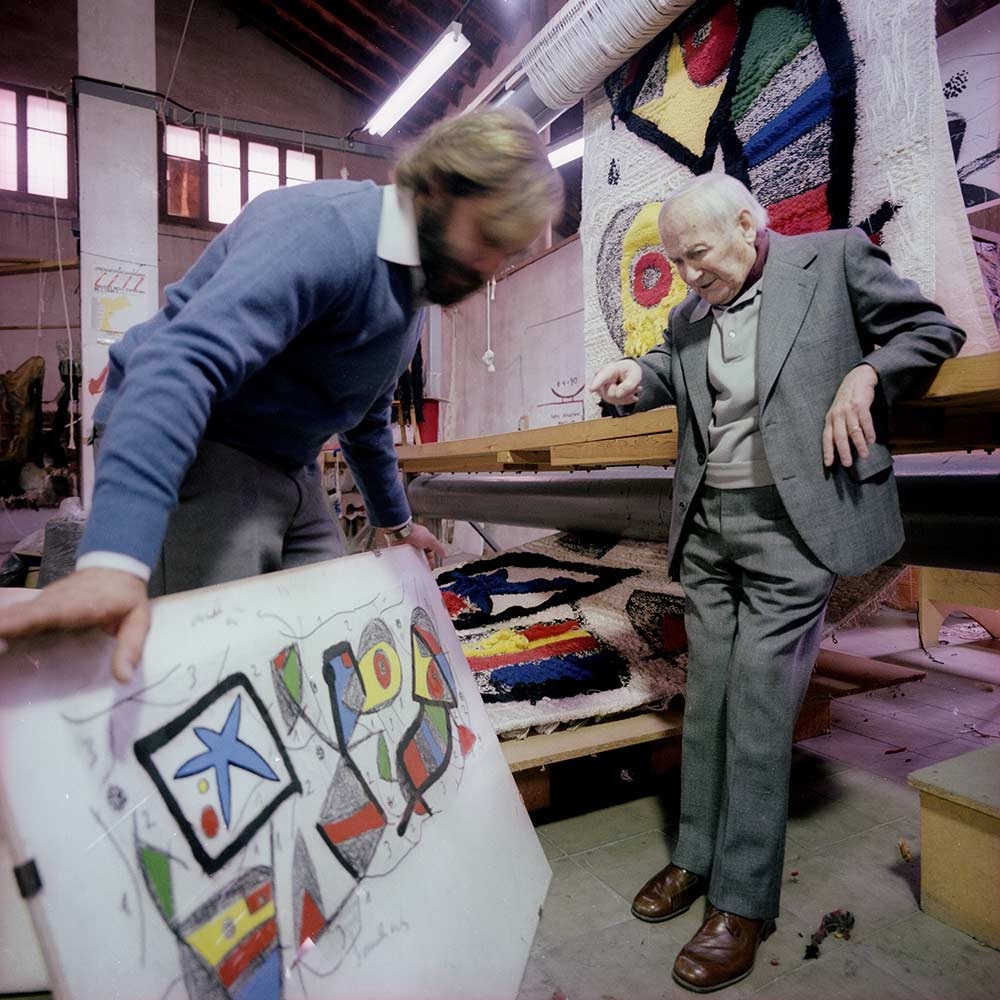 Joan Miró y Josep Royo en la Farinera, con la maqueta y el tapiz de la Fundación ”la Caixa”. Tarragona, octubre de 1980 © Fons F. Català-Roca – Arxiu Històric del Col·legi d’Arquitectes de Catalunya.
