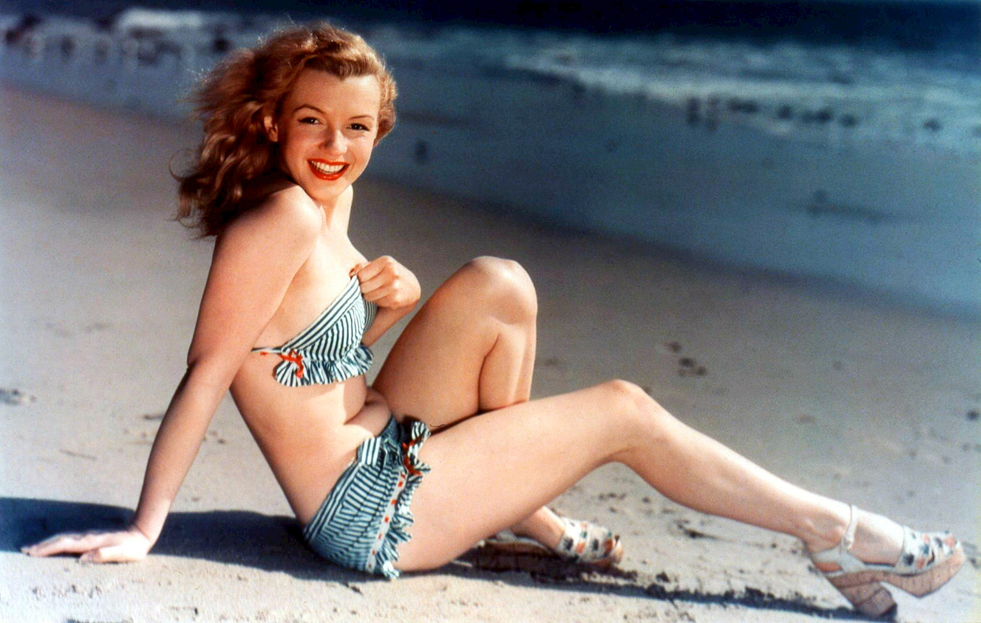 Monroe posando como modelo pin-up para una fotografía de postal, c. 1940. De Teichnor Bros., Boston - eBayfrontback, Dominio público.